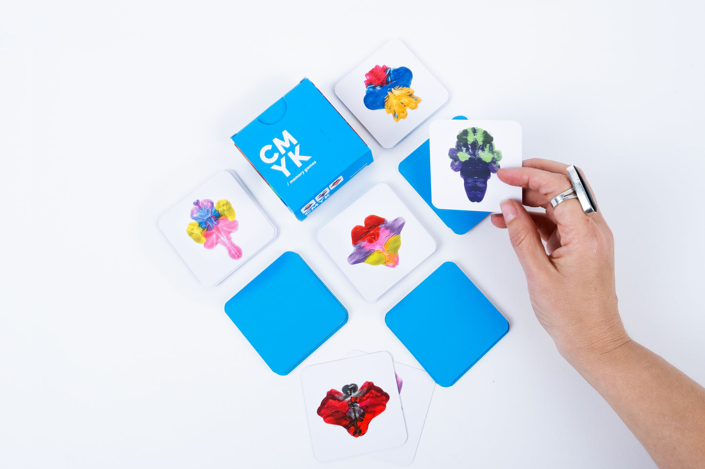 Colorful card game with hand holding a card on a white background